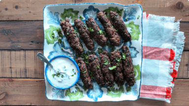 Seekh kebabs on skewers with sauce ready to be eaten.  Seekh kebabs on skewers with sauce ready to be eaten.