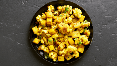 Bright Pakistani potatoes and cauliflower in a bowl. Bright Pakistani potatoes and cauliflower in a bowl.