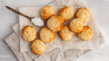 Browned orange and coconut cookies cooling on parchment paper.  Browned orange and coconut cookies cooling on parchment paper.